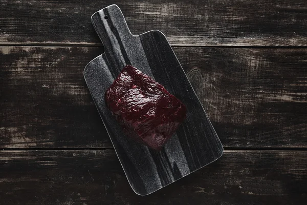 Whale steak on black desk wooden table