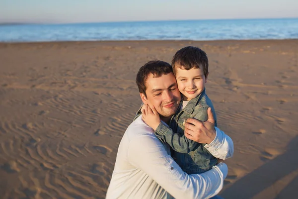 Father hugs his little son on a beach