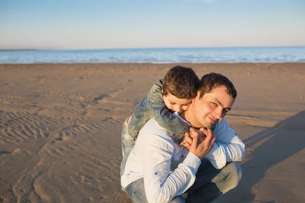 Little son hugs his father on a beach