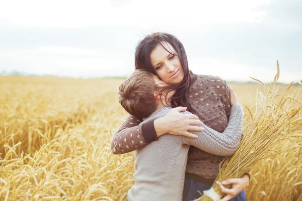 Portrait of a son kisses his mother on a field