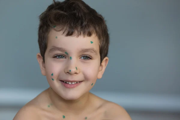 Portrait of a cute little boy with a green points