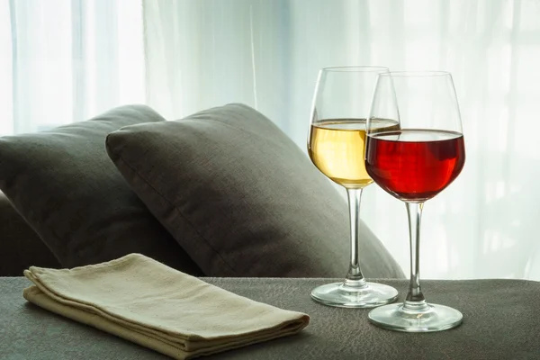 Two glasses of red and white wine in a living room