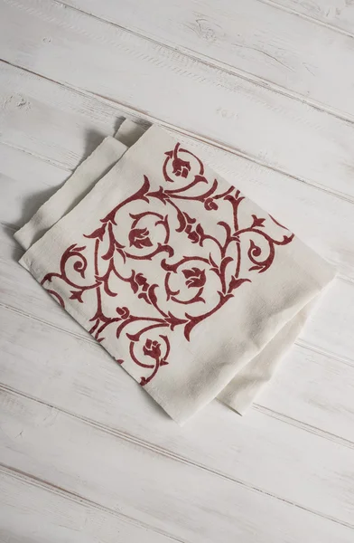 Cropped Photo of White Dinner Napkin with Red Floral Pattern
