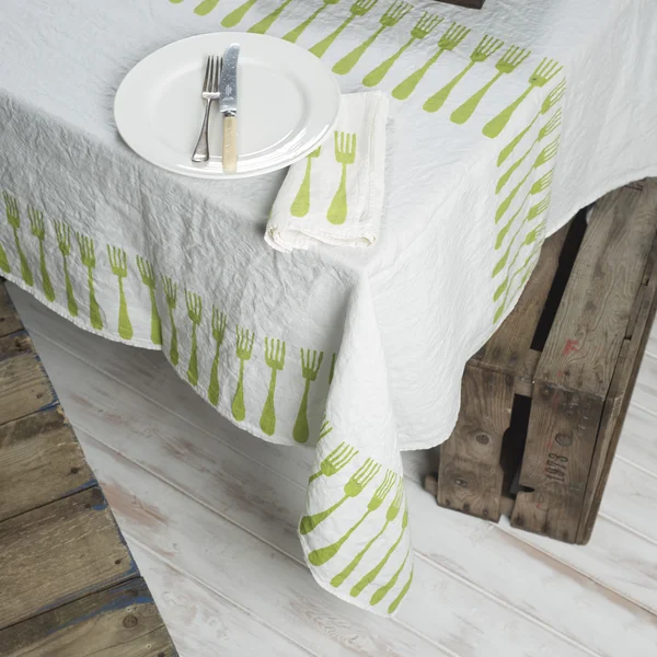 Dinnerware and Napkin on Table Covered in White Fork-Patterned L