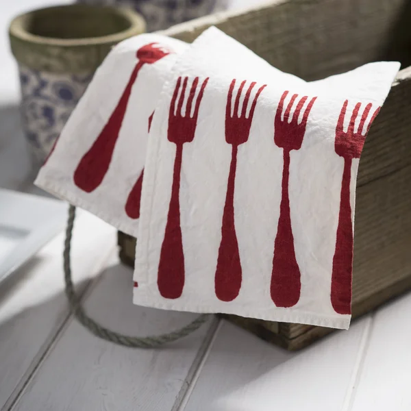 White Dinner Napkin with Red Fork Design on Small Crate