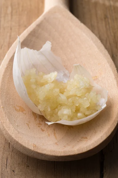 Crushed Garlic on Garlic Peel and Wooden Spoon