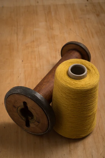 Empty Old Wooden Spool Beside Yellow Thread