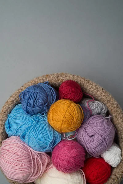 Balls of Colour Wool in Bowl on Grey Background