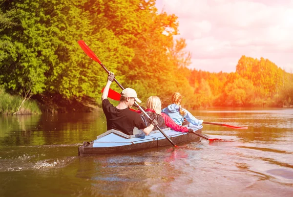 Young people are kayaking on a river in beautiful nature