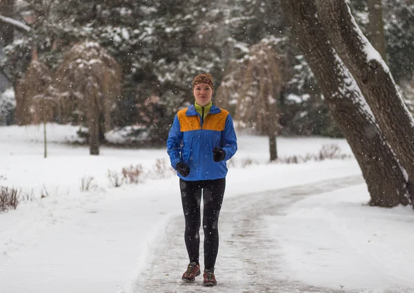 Young sport woman model jogging during winter training outside in winter