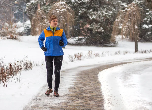 Young sport woman model jogging during winter training outside in winter