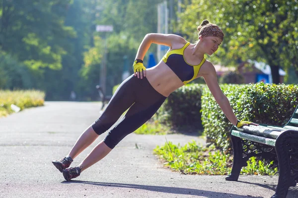 Sport woman doing plank during outdoor cross training workout