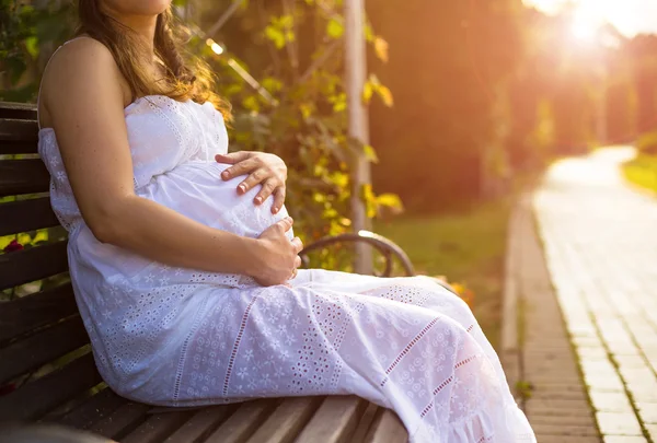 Pregnant woman sitting on bench
