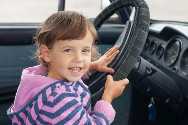 Little girl in car behind the wheel