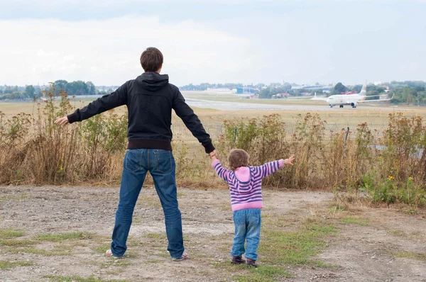 Dad and daughter watching as the plane prepares for takeoff