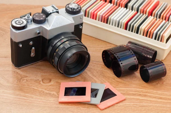 Vintage camera, slides and negatives on wooden table
