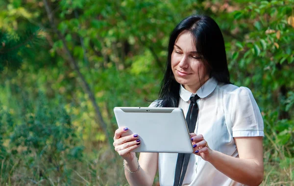 Young woman using digital tablet computer in the forest