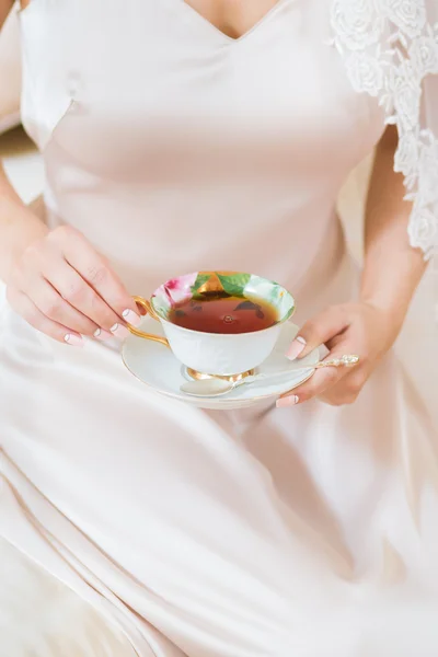 Portrait of the beautiful woman drinking tea in the morning