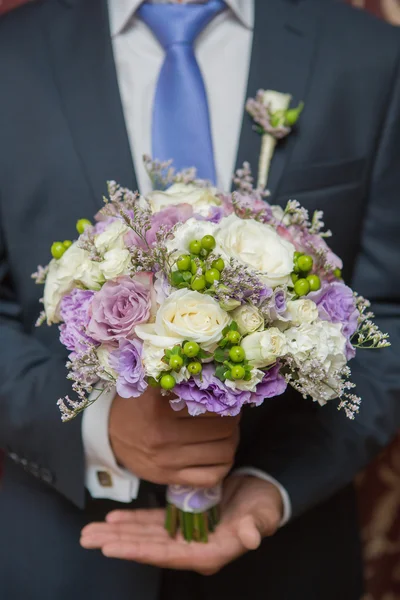 Wwedding bouquet in groom hand