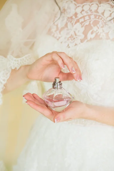 Bride applying perfume