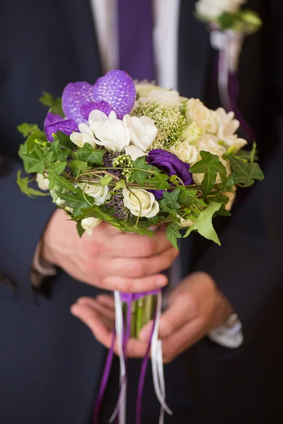 Wedding bouquet in groom hand