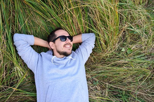 Smiling man lying on the grass