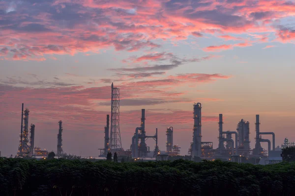 Twilight of oil refinery plant on skies exploded background.