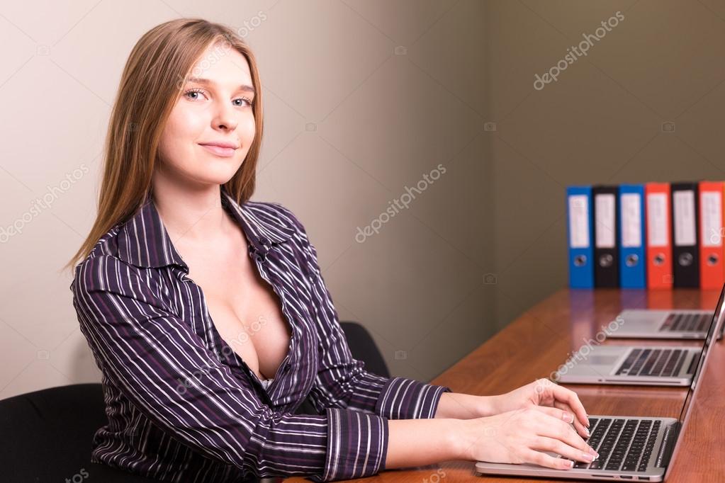 Секретарша с короткой стрижкой и с большой грудью дает сотруднику на рабочем столе