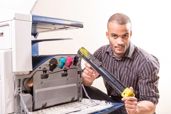 Man repairing color printer changing toner cartridge