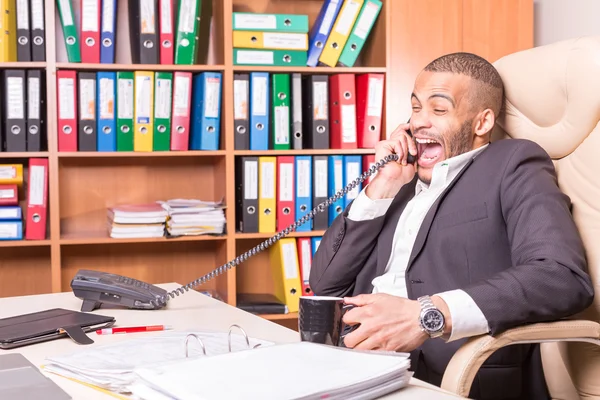 Laughing main talking on phone in office