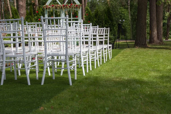 White wedding chairs on a green lawn, without decoration-2