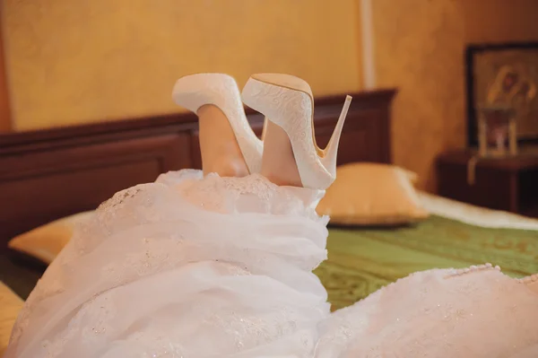 Close-up of a brides shoes is lying on the bed
