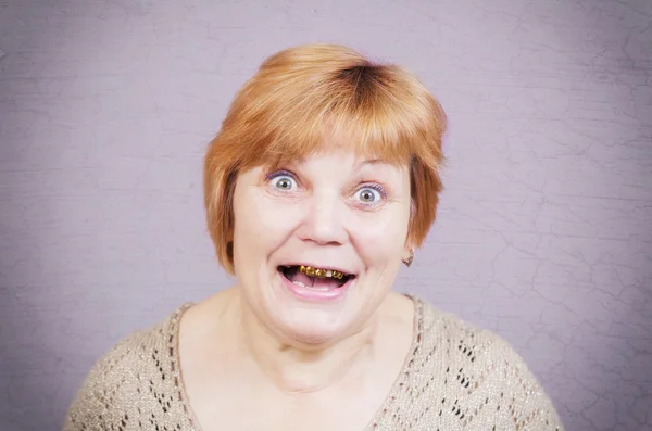 Very emotional gold teeth woman on a gray background