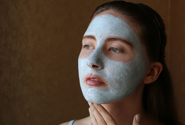 Girl doing cosmetic mask on her face