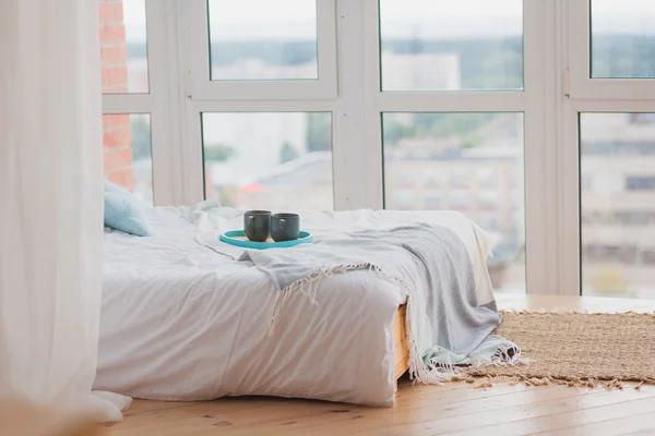 Two mugs on a tray white bed, breakfast concept