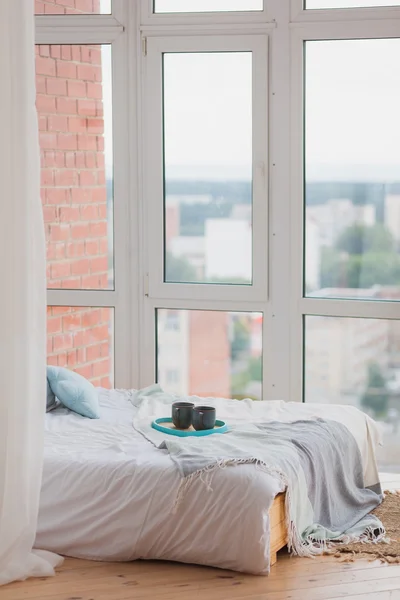 Two mugs on a tray white bed, breakfast concept