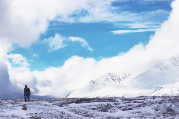 Backpacker go into the mountains. Happy travel concept. Mountain trekking. Man in harmony with nature. Winter mountain landscape.