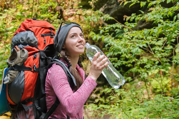Young woman tourist drinking water