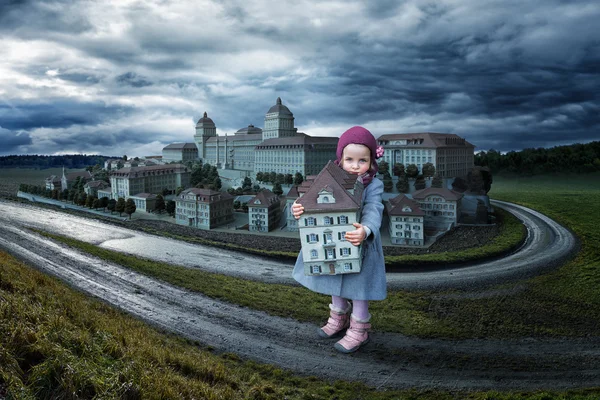 Little girl holding toy house