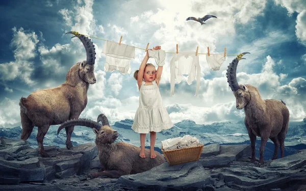 Girl hanging laundry standing on ibex