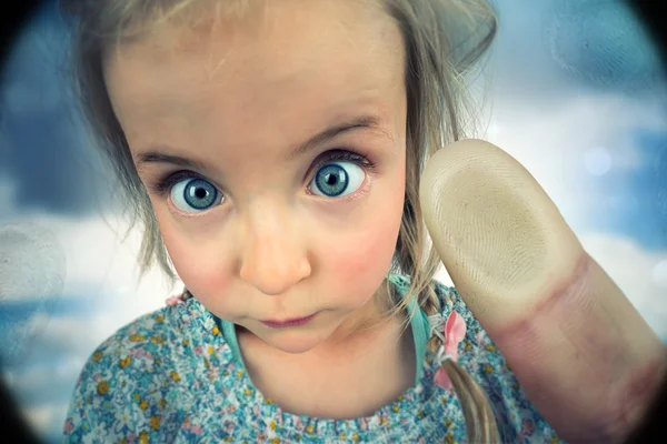 Little, cute girl pressing on peephole