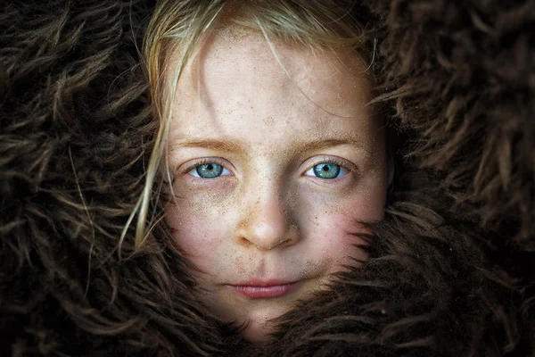 Girl with freckles in fur hat