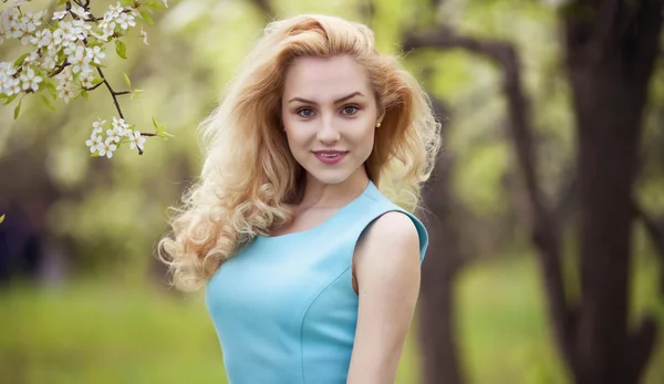 Smiling girl natural beauty, lovely female walking spring nature, portrait of young lovely woman in spring flowers