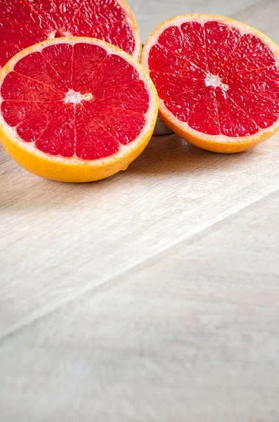 Halved red grapefruit on the table closeup