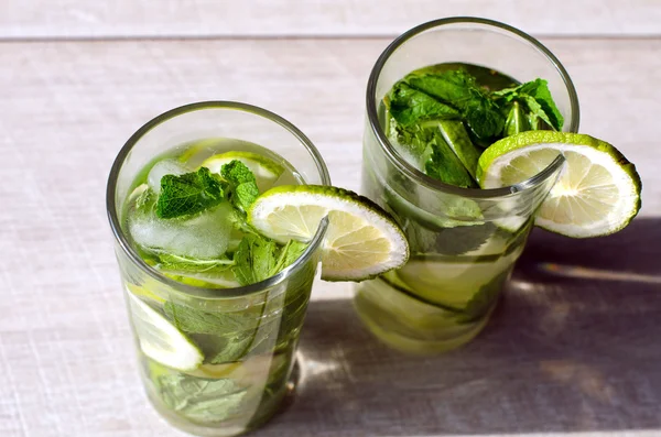 Detox water with lime and mint in two cups
