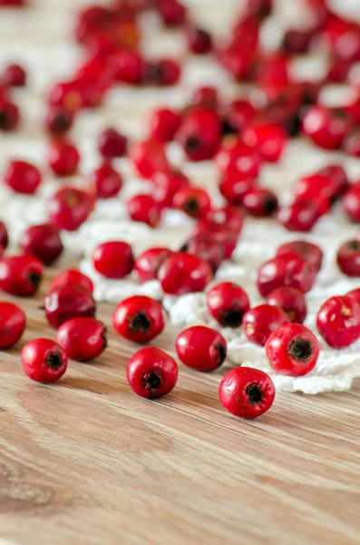 Hawthorn berries are scattered on the table