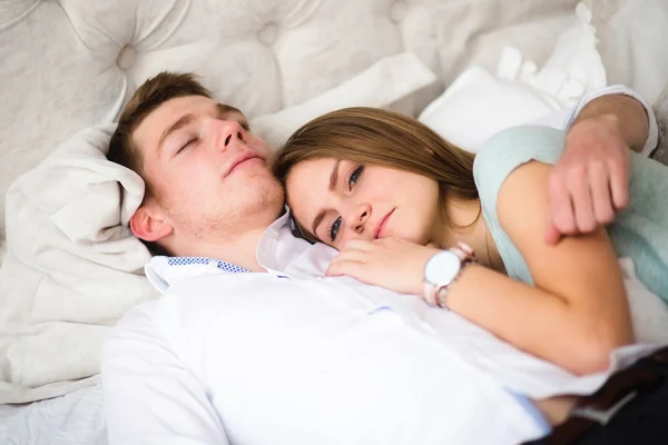 Young love couple in bed. Girl lying on the boy\'s shoulder
