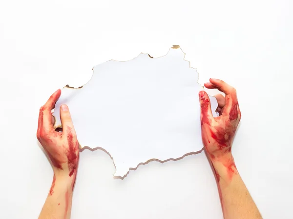 Bloodied woman\'s hands holding an old white sheet on a white background to the topic of Halloween