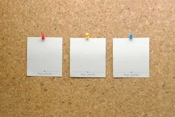 Paper cards posted on a cork board with tack pin