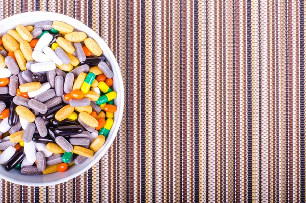 Plate of pills on striped cloth isolated, concept diet